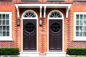 Twin Arched Dark Doors in Red Brick Wall with White Details
