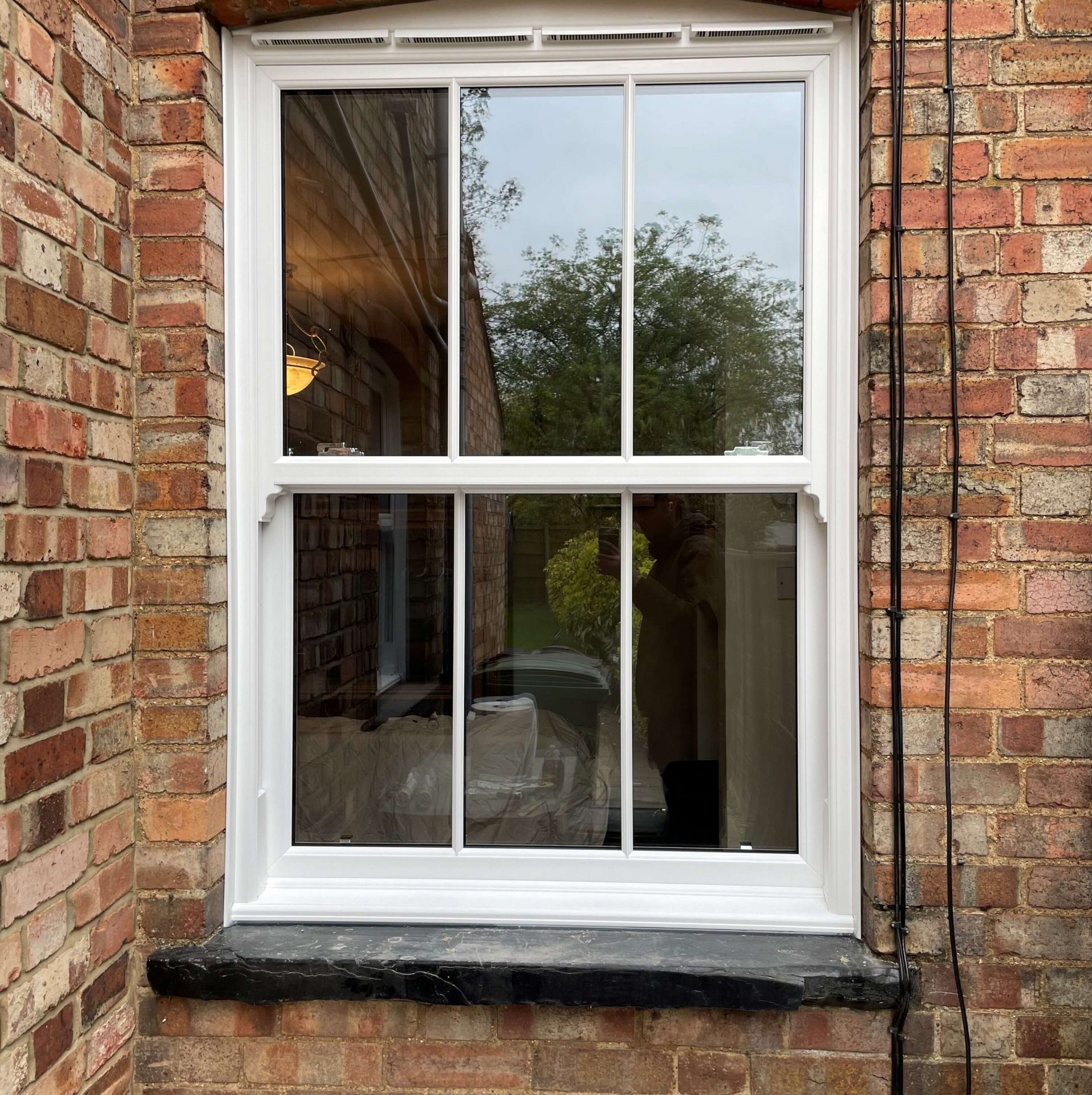 Modern living room with large windows, stylish furniture & light